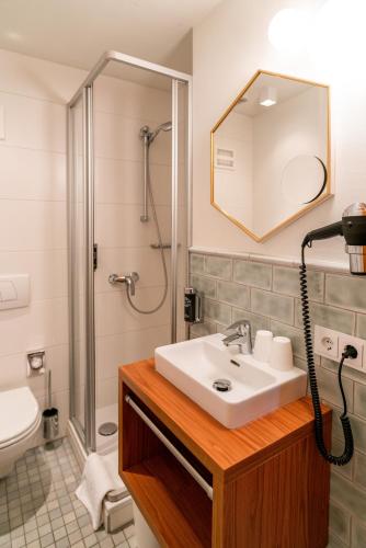 a bathroom with a sink and a shower at Cityhotel Trumer Stube in Salzburg