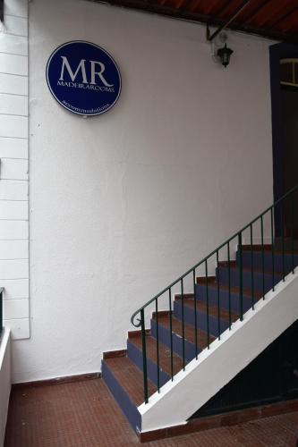 a sign on the side of a building with stairs at Madeirarooms in Funchal
