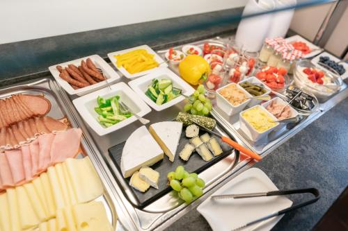 a tray of food with different types of cheese and meats at Cityhotel Trumer Stube in Salzburg