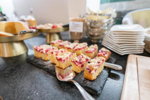 a bunch of food on a table with a spoon at Cityhotel Trumer Stube in Salzburg