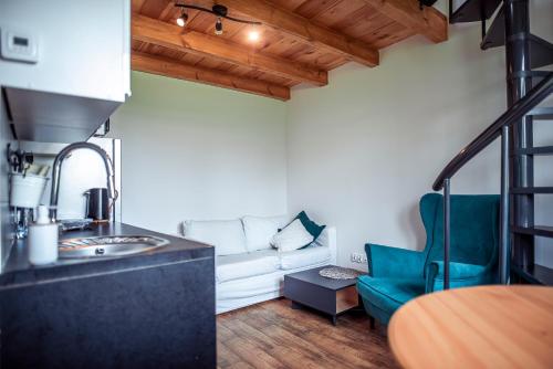 a living room with a white couch and a blue chair at Zimna Apartments in Kwidzyn