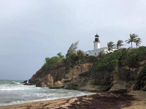 a lighthouse on top of a cliff next to the ocean at Oceanview Lighthouse Villa in Maunabo
