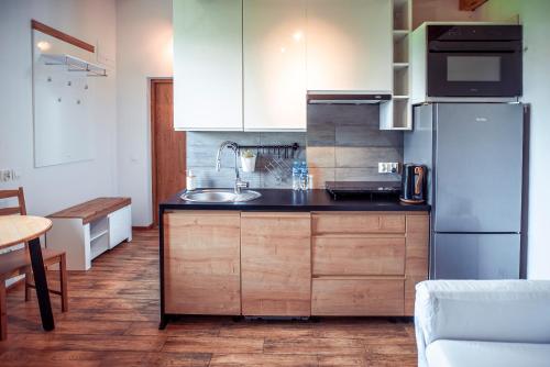 a kitchen with white cabinets and a stainless steel refrigerator at Zimna Apartments in Kwidzyn