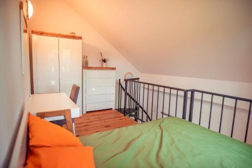 a bedroom with a bed and a desk and a staircase at Zimna Apartments in Kwidzyn