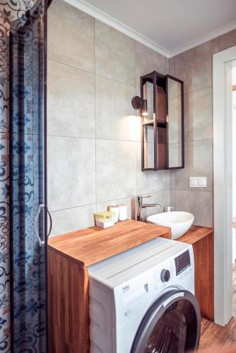 a bathroom with a washing machine and a sink at Zimna Apartments in Kwidzyn