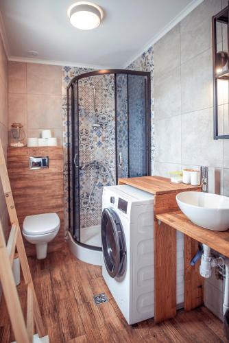 a bathroom with a washing machine and a sink at Zimna Apartments in Kwidzyn