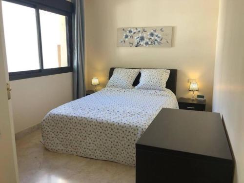 a bedroom with a bed and a table and a window at Roda Golf Resort ;Casa Sylva in San Javier