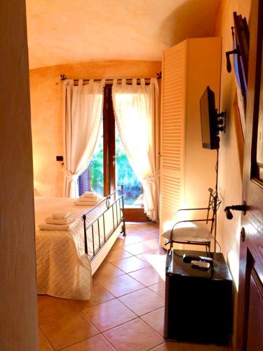 a bedroom with a bed and a tv and a window at Villa Franci in Santa Teresa Gallura
