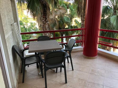 a table and chairs on a balcony with palm trees at HOTEL Apartments ARDO in Golem