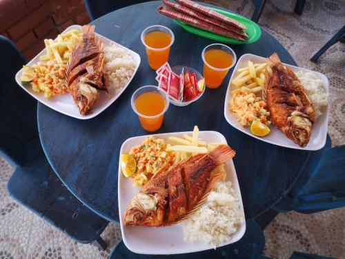 three plates of food on a table with fish and french fries at Finca Campestre Villa del Campo in Santa Rosa de Cabal