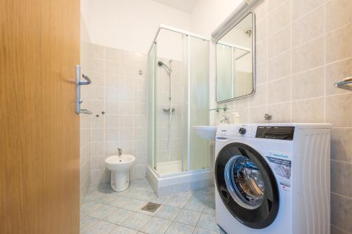 a bathroom with a washing machine and a toilet at Hostel Kronotop in Triglav National Park in Log pod Mangartom