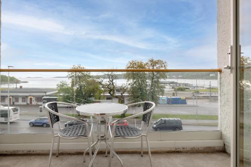 a table and two chairs on a balcony with a window at Quality Hotel Grand Larvik in Larvik