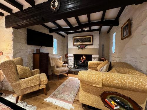a living room with a couch and chairs and a fireplace at Picket Post House Bed & Breakfast in Catterall