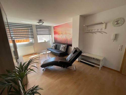 a living room with a chair and a couch at Ferienwohnung Dinkelberg in Steinen