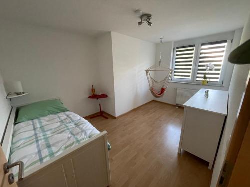 a bedroom with a bed and a desk and window at Ferienwohnung Dinkelberg in Steinen