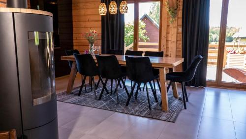 a dining room with a table and chairs and a refrigerator at Apartament Sasinowe Zacisze in Sasino