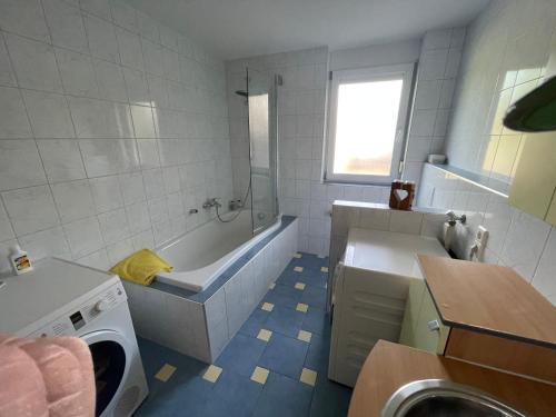 a bathroom with a tub and a sink at Ferienwohnung Dinkelberg in Steinen