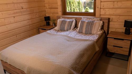 a bedroom with a bed in a log cabin at Apartament Sasinowe Zacisze in Sasino