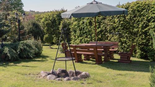 a picnic table and an umbrella in a yard at Apartament Sasinowe Zacisze in Sasino
