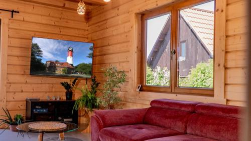a living room with a red couch and a lighthouse at Apartament Sasinowe Zacisze in Sasino