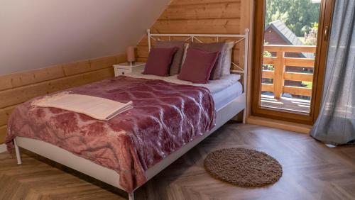 a bedroom with a bed and a balcony at Apartament Sasinowe Zacisze in Sasino