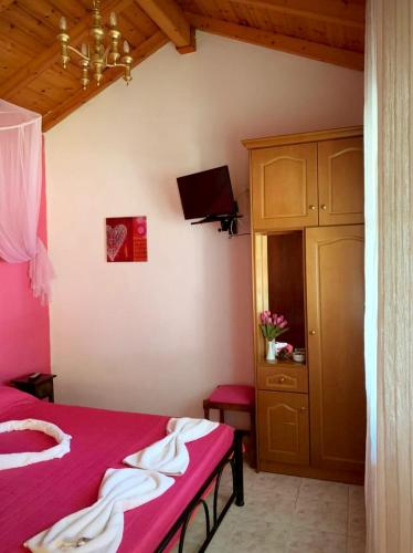 a bedroom with a red bed and a cabinet at Palma Sidari Corfu in Sidari