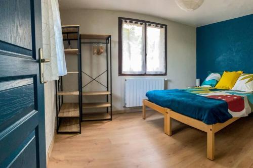 Un dormitorio con una cama con paredes azules y una ventana en maison à Joyeuse sud Ardèche, en Joyeuse