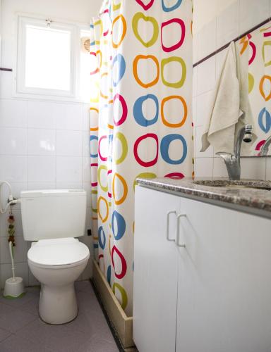 a bathroom with a toilet and a sink and a window at Yaakov's Apartment in Migdal Ha‘Emeq