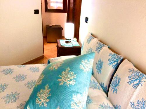 a couch with blue and white pillows in a room at Villa Franci in Santa Teresa Gallura
