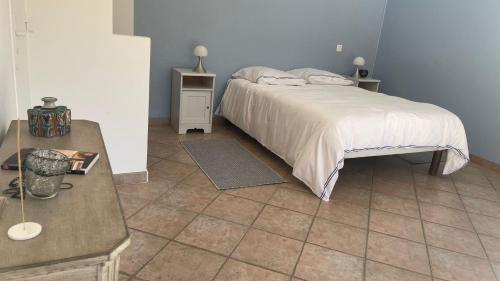 une chambre avec un lit et un sol carrelé dans l'établissement Maison d'Hotes Le Boulou, à Saint-Cyr-sur-Mer