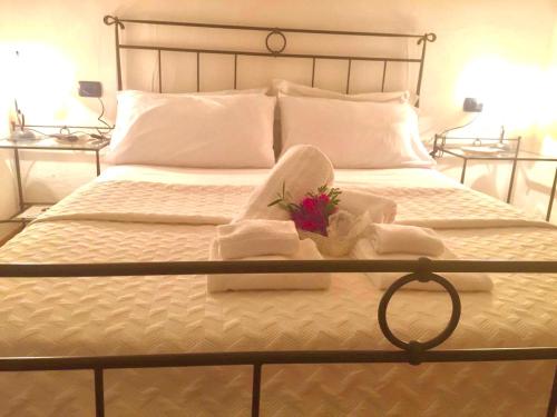 a bed with towels and a bouquet of flowers on it at Villa Franci in Santa Teresa Gallura