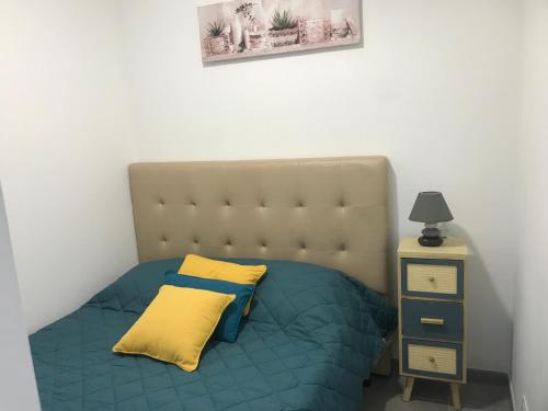 1 dormitorio con 1 cama con almohada amarilla en Superbe studio entièrement refait a neuf, en Figeac