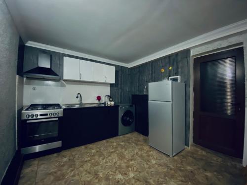 a kitchen with a white refrigerator and a stove at Cottage Kesane in Stepantsminda