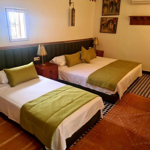 two beds in a hotel room with two beds sidx sidx sidx at Riad Fes Nass Zmane in Fès