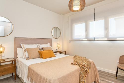 een slaapkamer met een bed met witte muren en ramen bij AB Vialia Estación , Parking and Pool in Málaga