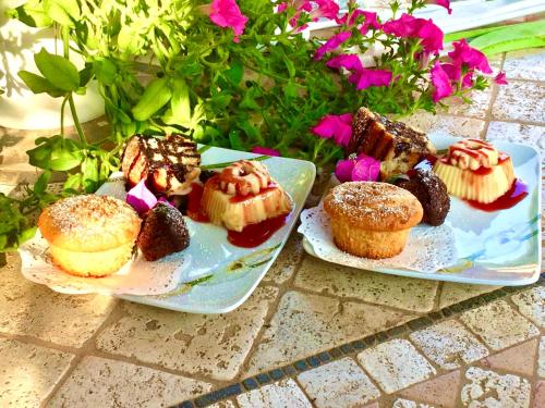 two plates of pastries and muffins on a table at Villa Franci in Santa Teresa Gallura