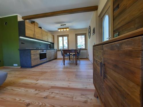 a large kitchen with wooden floors and a table at CasAmici in Bognanco