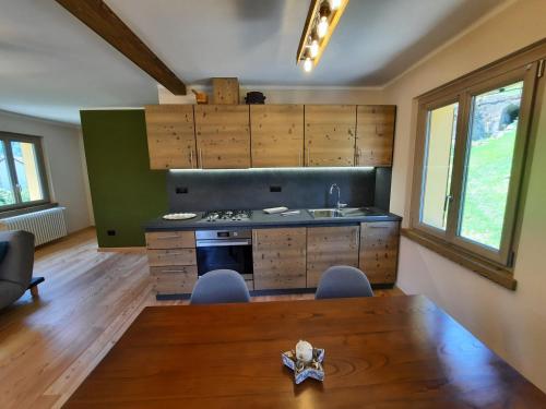 a kitchen with a wooden table and a wooden floor at CasAmici in Bognanco