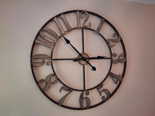 a clock is hanging on a wall at CasAmici in Bognanco