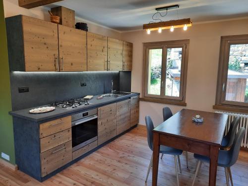 a kitchen with a table and a stove and a dining room at CasAmici in Bognanco