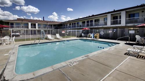 a swimming pool in front of a building at Super 8 by Wyndham Woods Cross - Salt Lake City North in Woods Cross