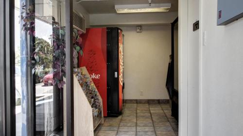 a hallway of a building with a red and black refrigerator at Super 8 by Wyndham Woods Cross - Salt Lake City North in Woods Cross