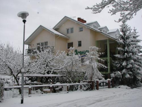 a house with snow covered trees and a street light at Dom Wypoczynkowy Anna - opcjonalnie śniadania w Starej Piekarni in Kołobrzeg
