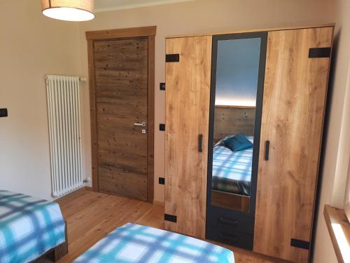a room with a bed and a closet with a mirror at CasAmici in Bognanco