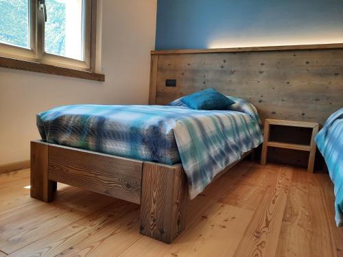 a bedroom with a bed with a blue blanket on it at CasAmici in Bognanco