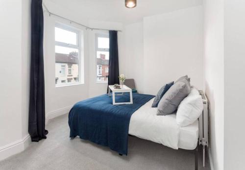 1 dormitorio con 1 cama con manta azul y mesa en Spaces by Hexagon en Liverpool