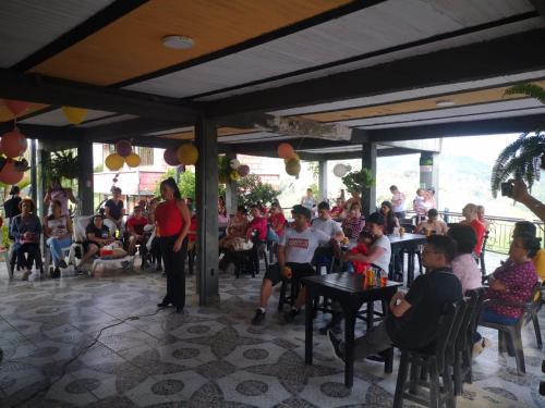 a group of people sitting at tables in a restaurant at Finca Campestre Villa del Campo in Santa Rosa de Cabal