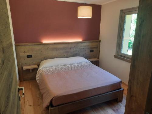 a bedroom with a bed in a room with a window at CasAmici in Bognanco