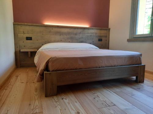 a bedroom with a bed with a wooden headboard at CasAmici in Bognanco