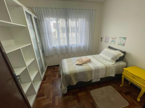 a small bedroom with a bed and a window at Apartamento para 9 pessoas - Blumenhaus 201 - uma quadra da Rua Coberta! in Gramado